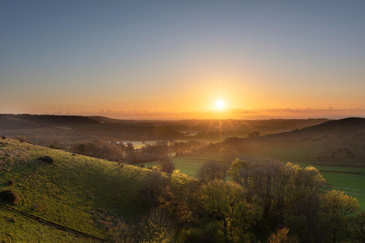 Photograph of the Folkestone Downs, rolling countryside, at sunrise.