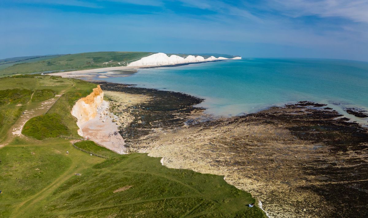 Photograph of the White Cliffs of Dover with rolling countryside behind.
